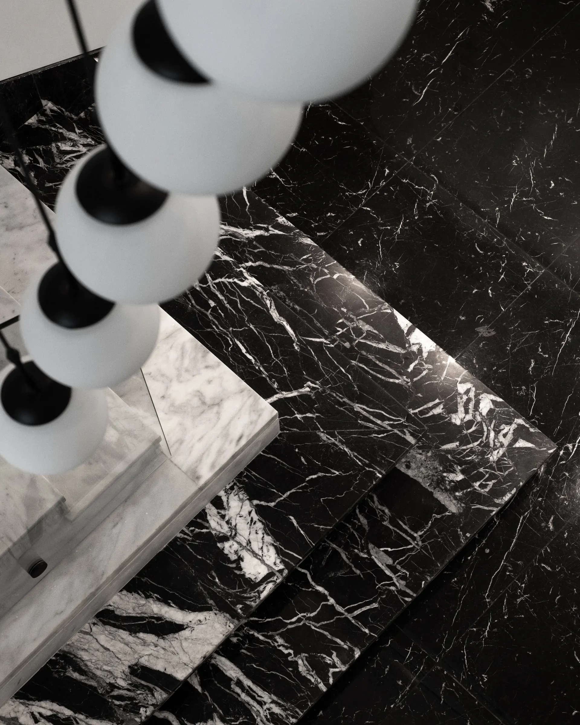 Glass spheres over black marble, seen from above.