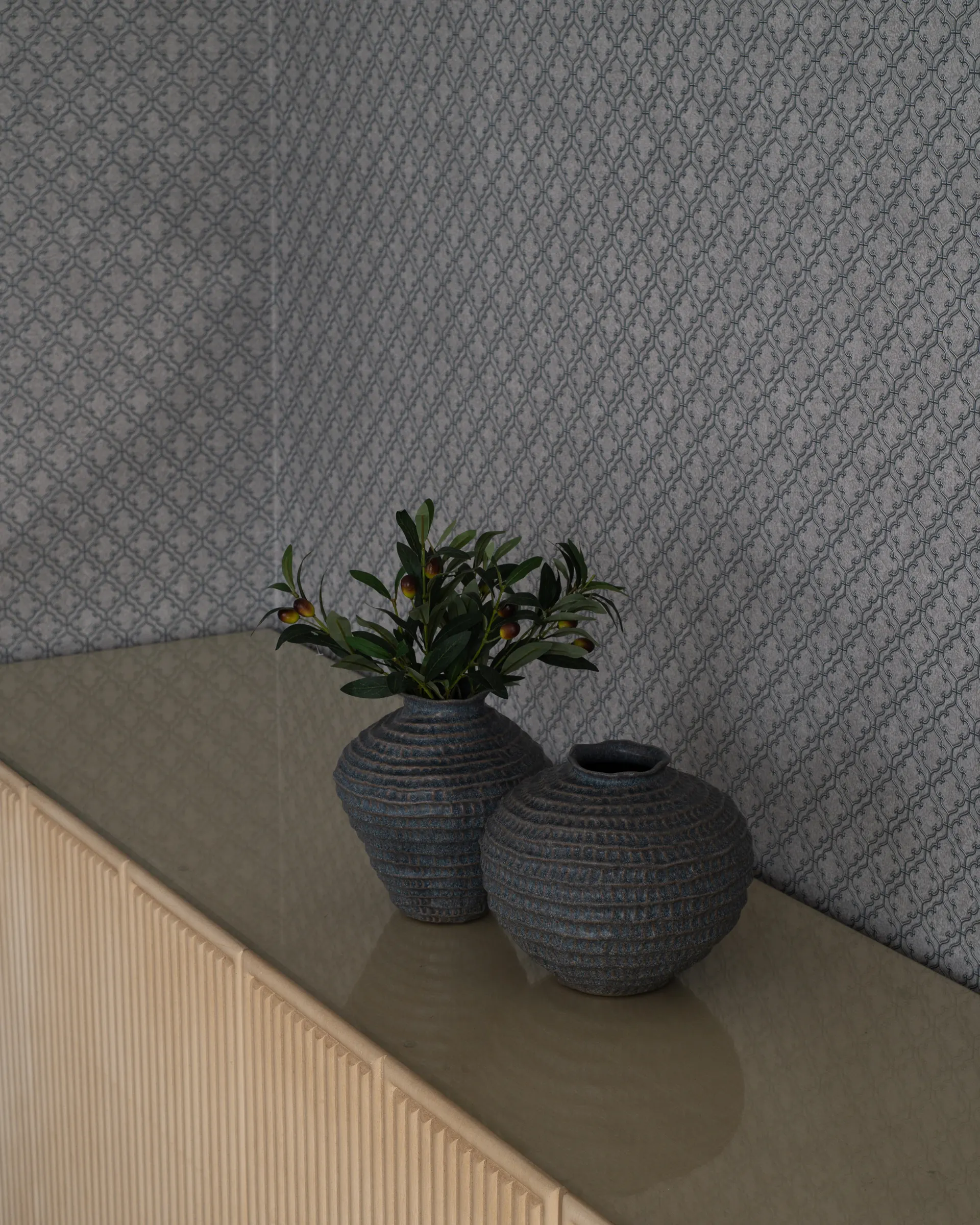 Two ceramic vases on a fluted sideboard against patterned wallpaper.