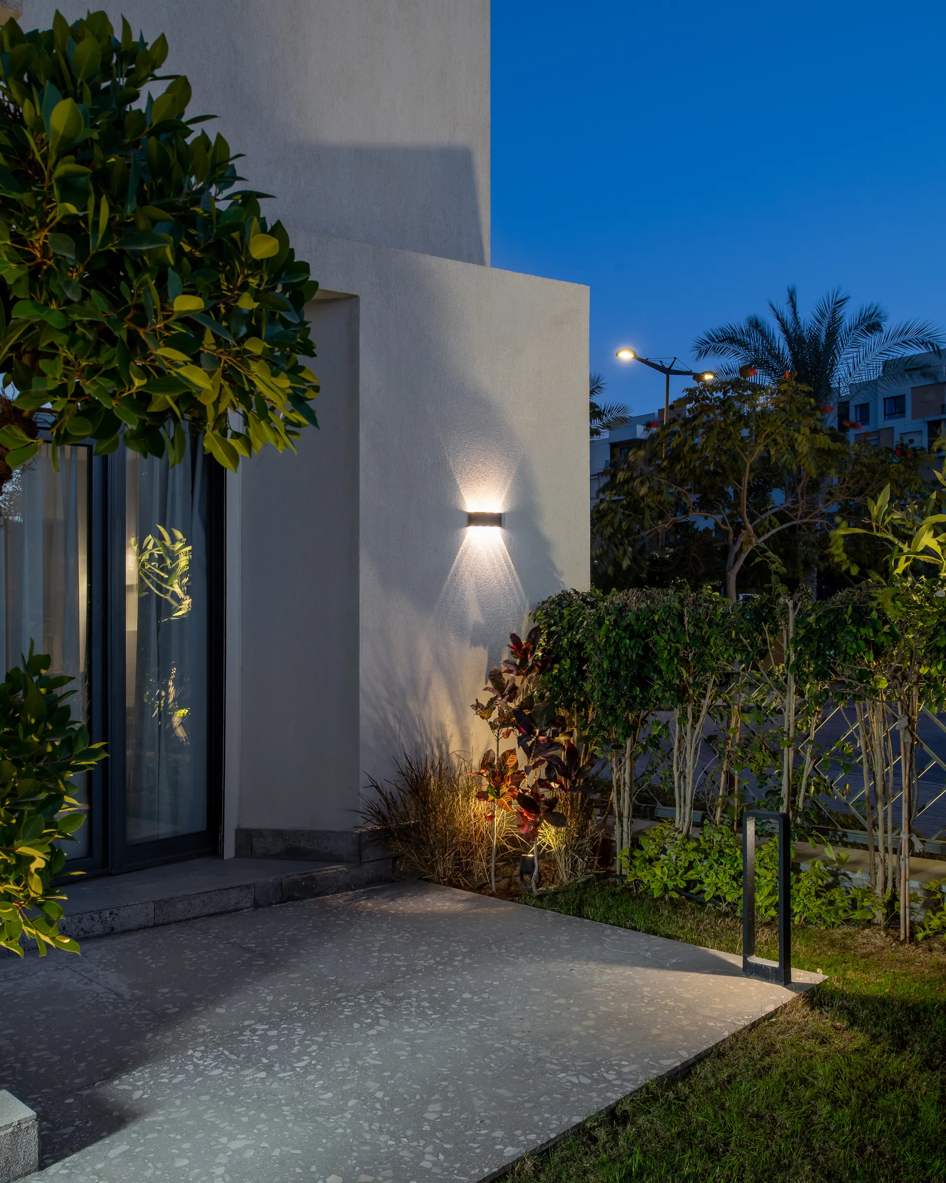 The entrance at dusk, render and planting lit from below.