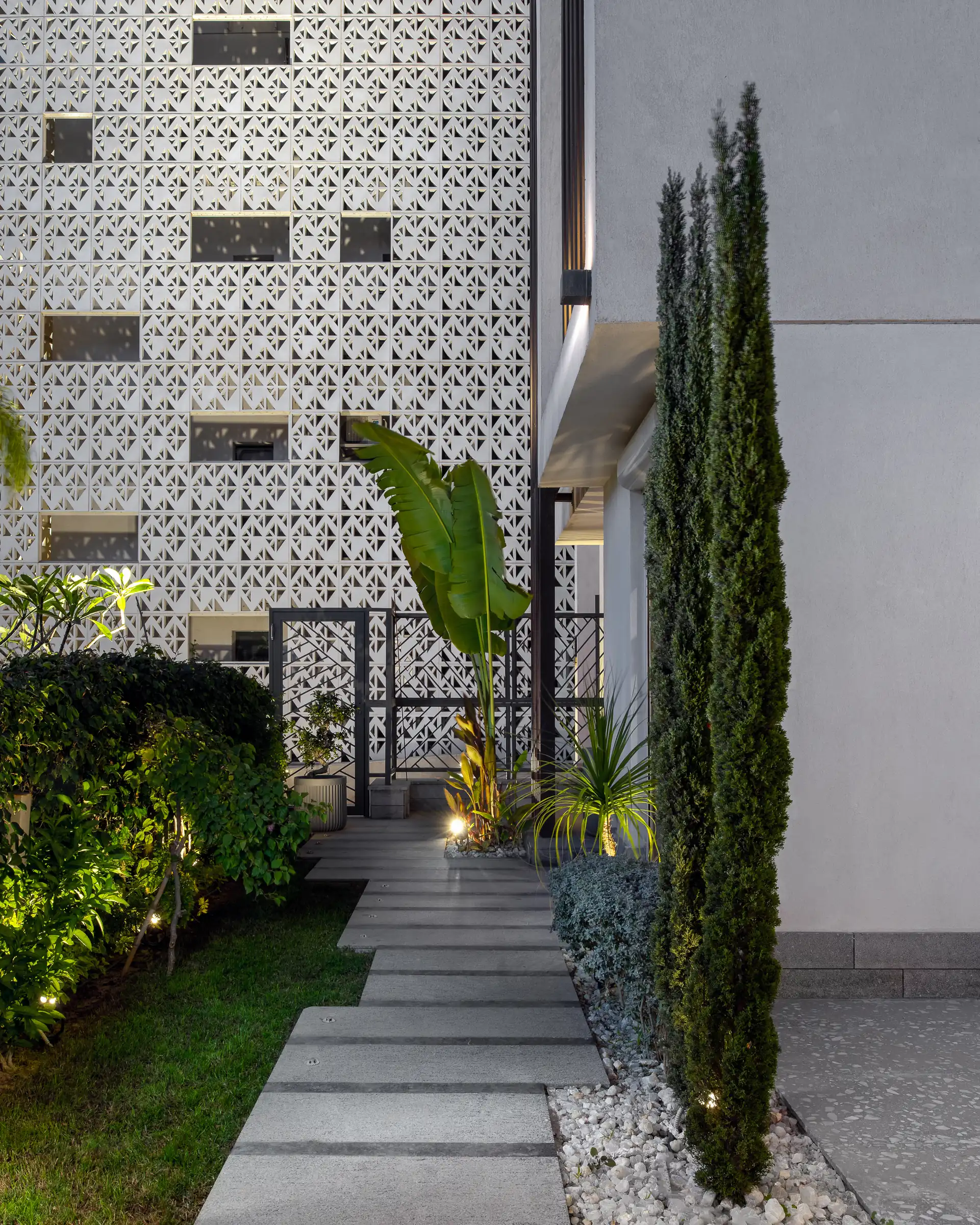The screen wall from the path, cypress against render.